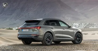 2025 Audi Q8 e-tron electric SUV parked in front of modern glass building
